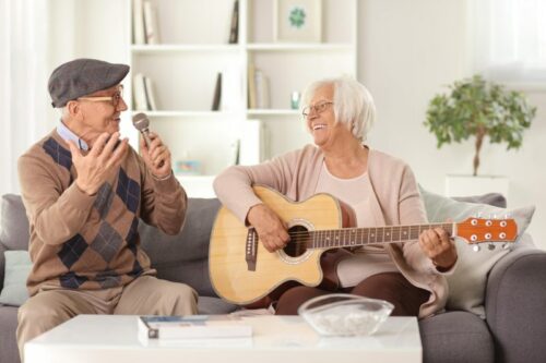 Couple de séniors qui chante avec une guitare